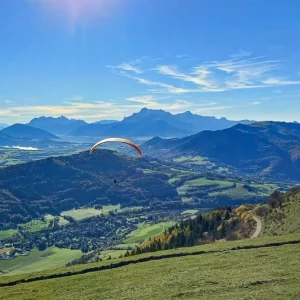 Vue aérienne panoramique sur les lacs de la Matheysine et les Alpes depuis un parapente.