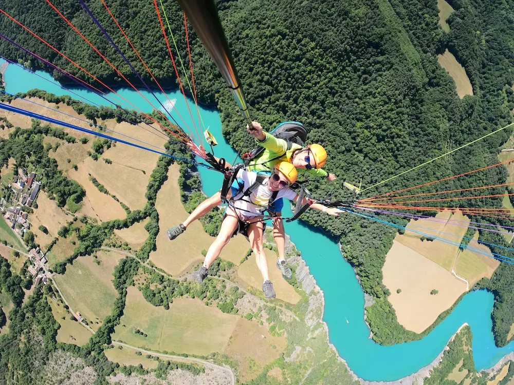 Moniteur de parapente biplace au-dessus du lac de Monteynard en Isère.